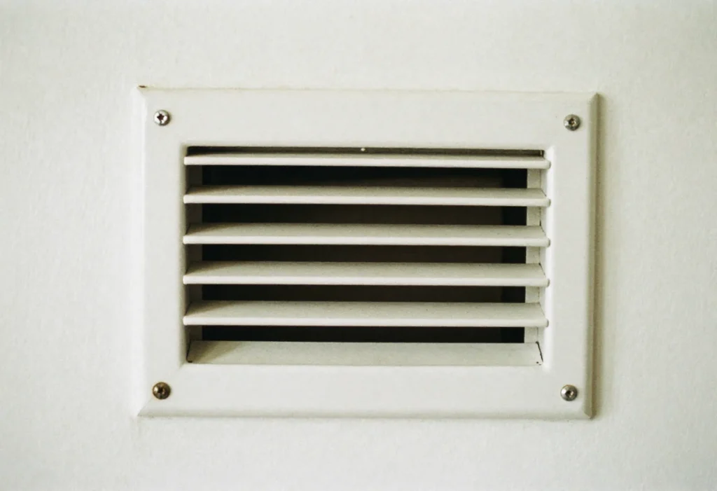 Close-up of a wall return air vent grille without a filter installed
