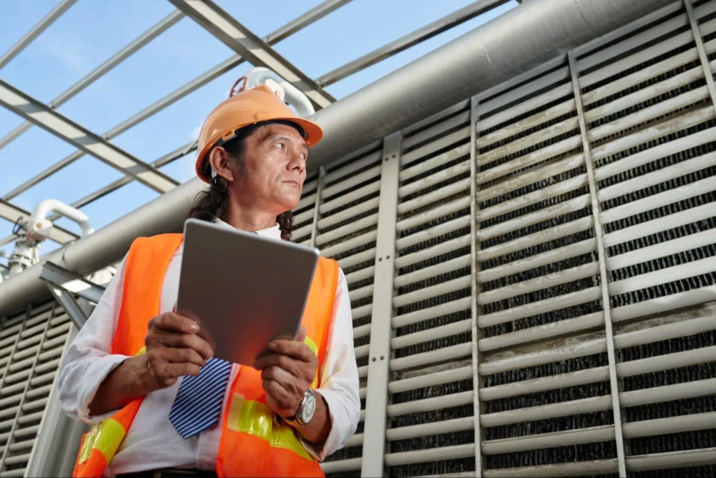 Professional checking large HVAC unit to evaluate air quality and airflow in a building
